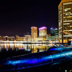 Baltimore, Maryland, USA - December 21, 2016: Night view to Baltimore Inner Harbor - the main tourist destination and port of call for cruise ships. Historic submarine USS Torsk in foreground.