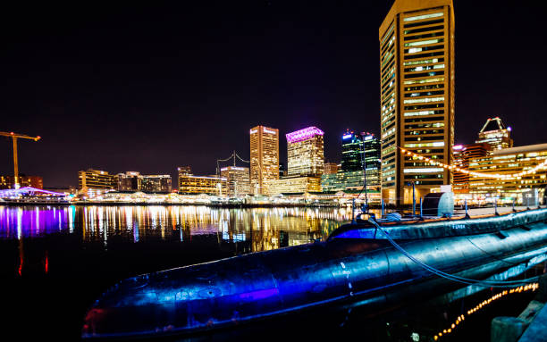 Baltimore, Maryland, USA - December 21, 2016: Night view to Baltimore Inner Harbor - the main tourist destination and port of call for cruise ships. Historic submarine USS Torsk in foreground.